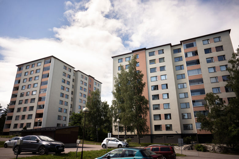 Kaksi kerrostaloa, joiden edustalla olevalla parkkipaikalla on autoja pysäköitynä.