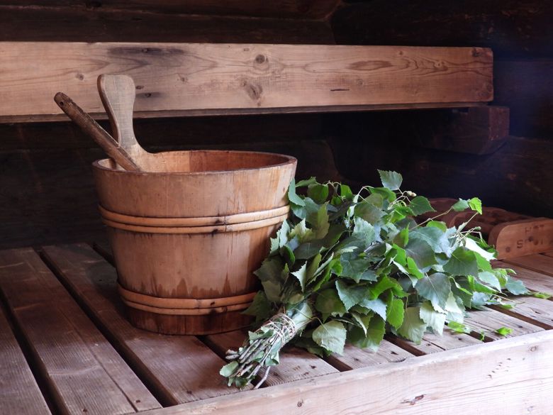 Saunakiulu ja vihta ovat saunanlauteilla vierekkäin.