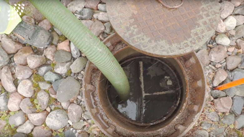 Emptying a septic tank with a hose.