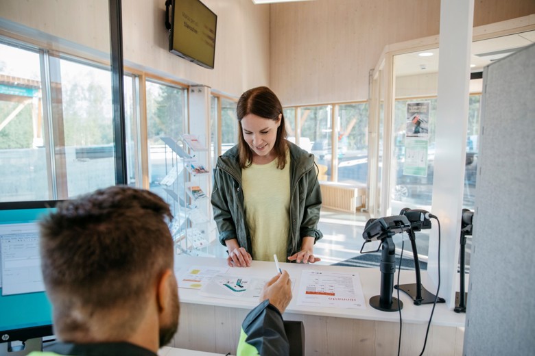 A woman looks at a map at the customer service desk of a Sortti Station.