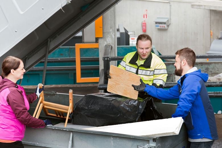 Sortti-aseman työntekijä auttaa asiakkaita lajittelussa.