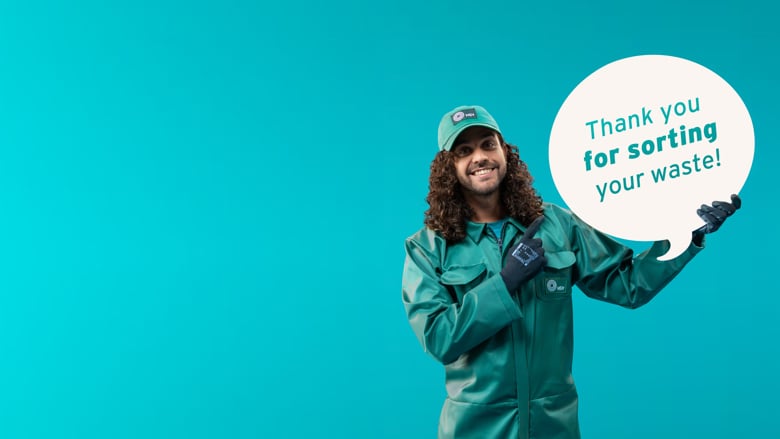 A person points to a sign that says: Thank you for sorting your waste!